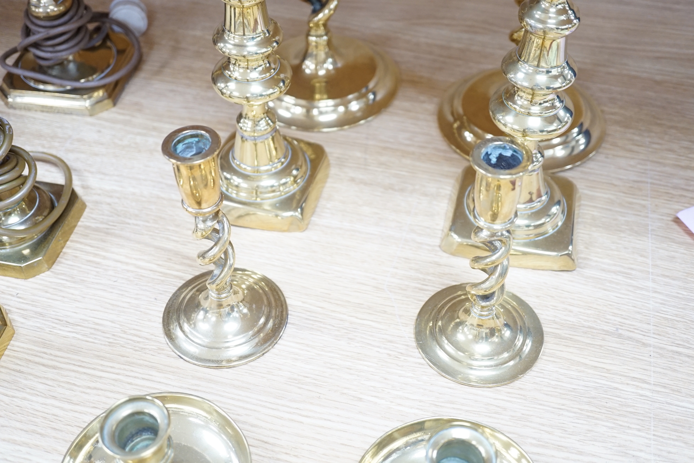 Four pairs of brass candlesticks, and another three converted to lamps, tallest 31cms high